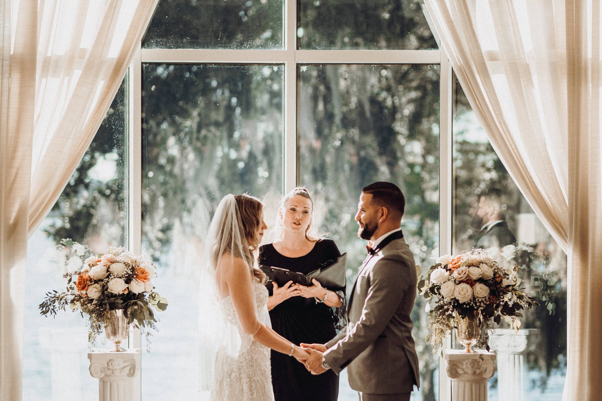 Bride and groom exchanging vows in a sunlit ceremony